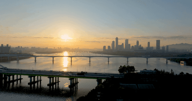 도시 스카이라인과 강 위의 일출