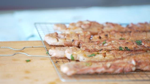 Grilled pork ribs with seasoning on a rack