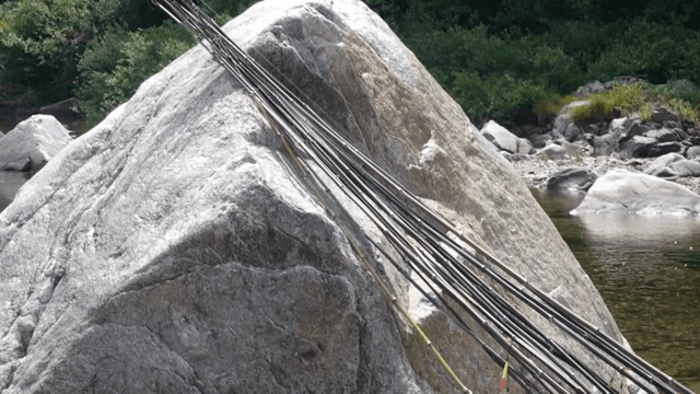 Fishing rods resting on river rocks