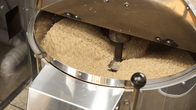 Sesame seeds being roasted in a machine