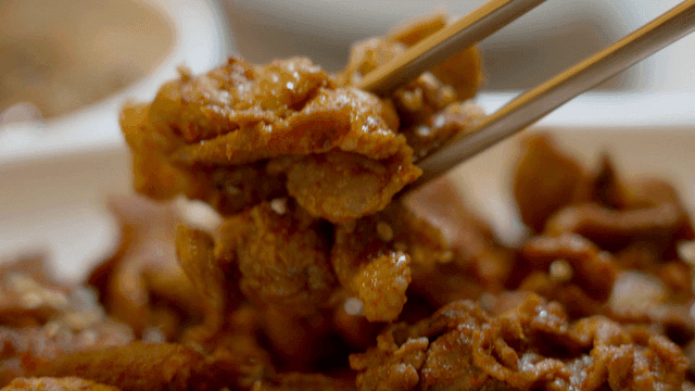 Spicy Korean pork being picked up with chopsticks