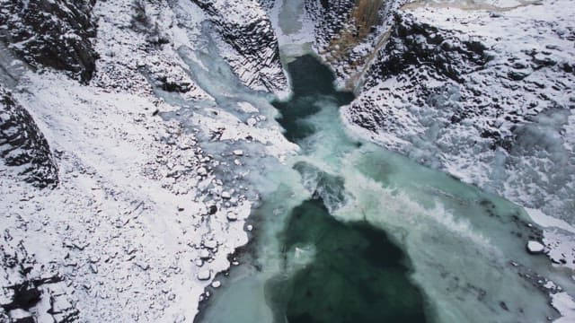 Frozen river between snowy cliffs