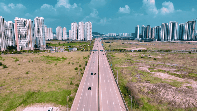 Highway leading to city with high-rise buildings