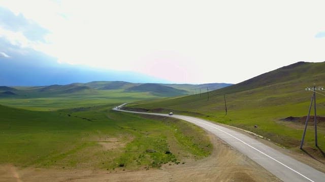 Winding road through vast green hills