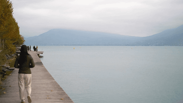 Peaceful woman walking along lakeside promenade