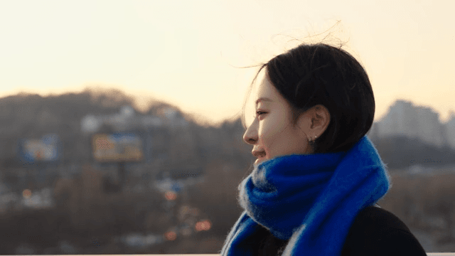 Woman in a blue scarf  watching the view