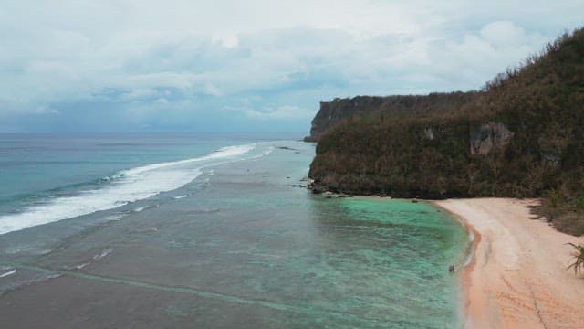 Serene beach with waves and cliffs