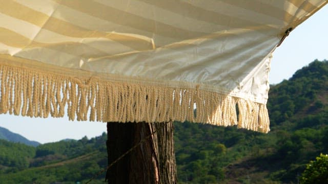 Sunny striped canopy and green mountains