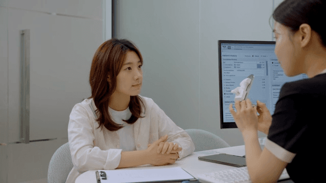 모형물을 보여주며 상담을 하는 상담실장