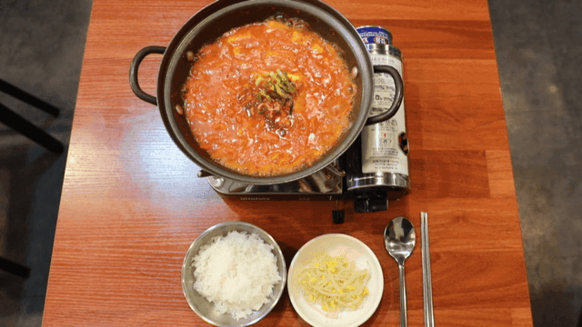 Kimchi stew boiling in pot on gas burner