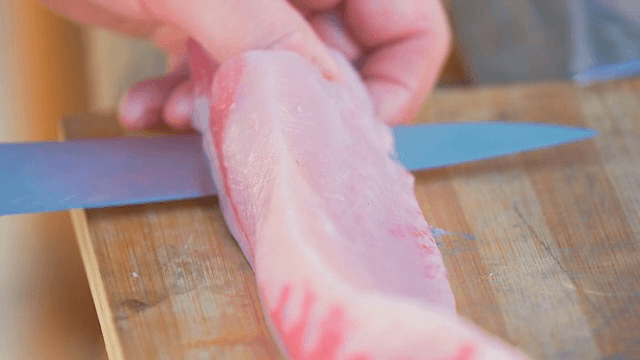 나무 도마 위에서 생선을 자르는 모습