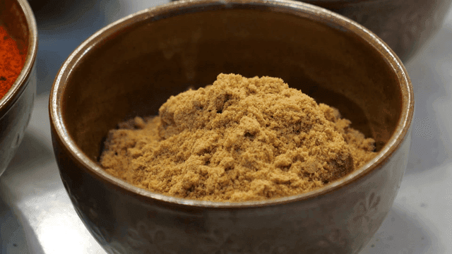 Bowl of brown meju powder on table