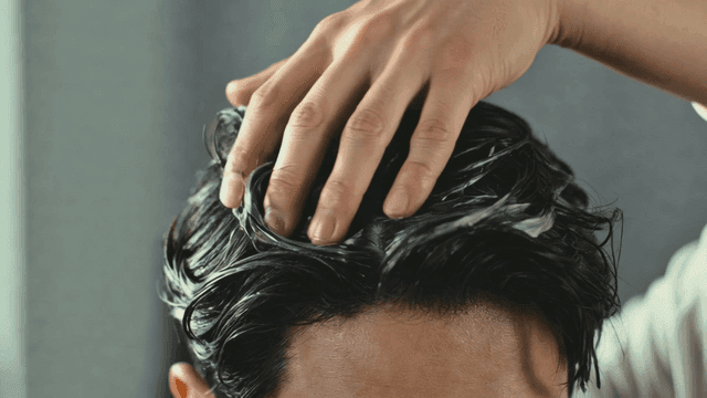 Man applying hair product to wet hair