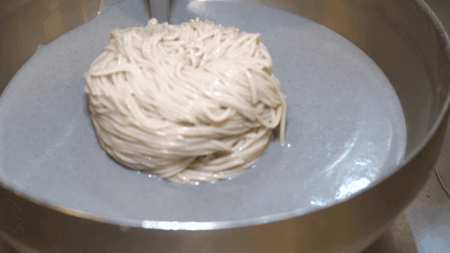 메밀면 위로 부어지는 진한 서리태 국물