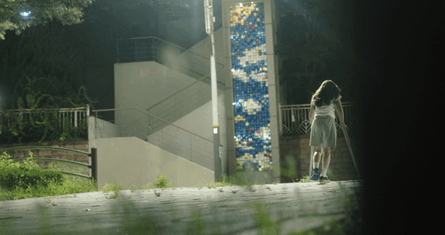 Person walking with crutches at night