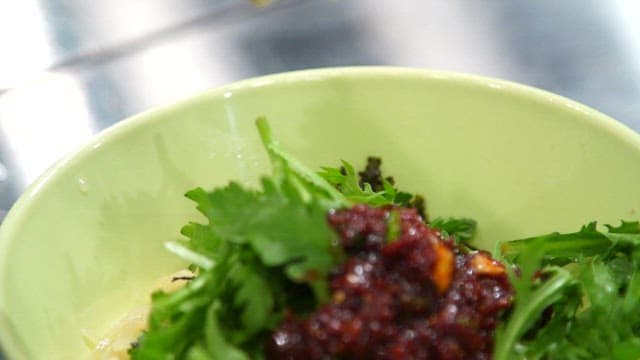 Placing fish cakes in a bowl with spicy sauce and mugwort