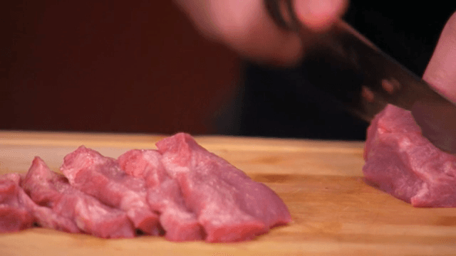 나무 도마 위에서 생고기 자르기