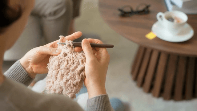 실내에서 뜨개질하는 여성