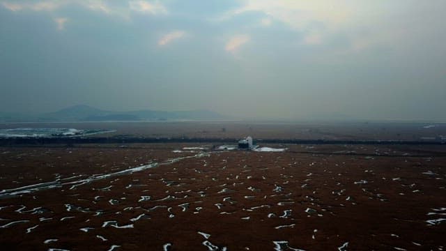 Vast marshland with a distant building