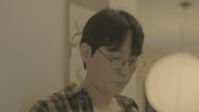 Man with glasses guiding woman to home entrance