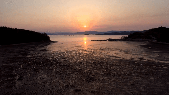 고요한 해변 위로 지는 해