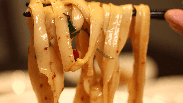 Spicy hand-cut noodles picked up with chopsticks