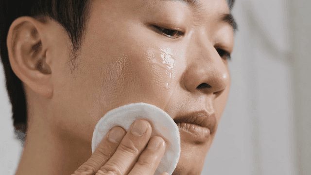 Man applying skincare products with pad