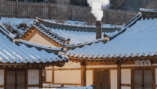 굴뚝에서 하얀 연기 나오는 한옥 마을