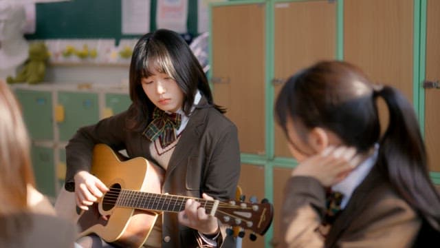 Student playing guitar in a classroom