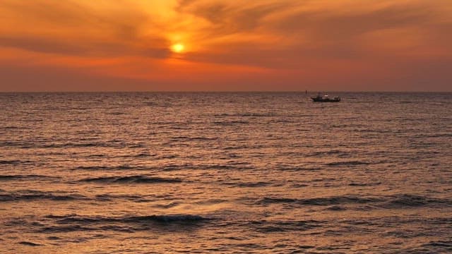 Serene sunset over the ocean with a boat