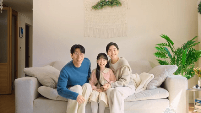 Family poses together on a sofa for a photo