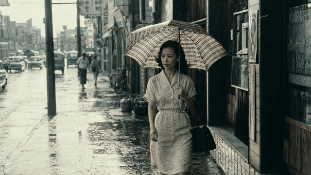Woman walking with umbrella on rainy street in 1970s