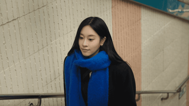 Woman wearing a blue scarf climbs the subway stairs