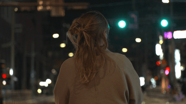 Back view of woman standing on road at night