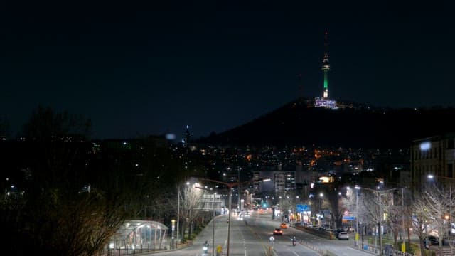 Night view of a city street with a tower