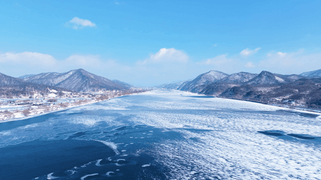 Frozen river with snowy mountains