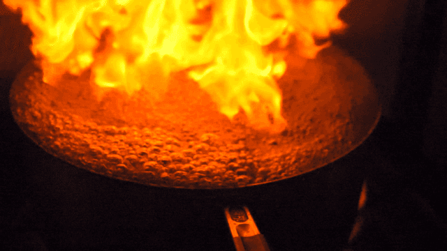 Boiling pot with flames shooting up on stove