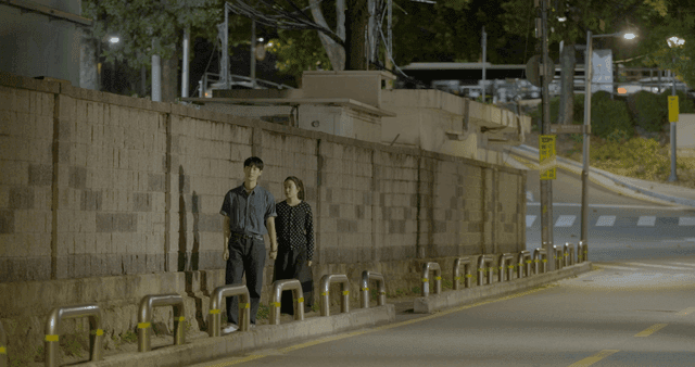 밤에 손을 다시 잡고 조용한 거리에서 걷는 커플