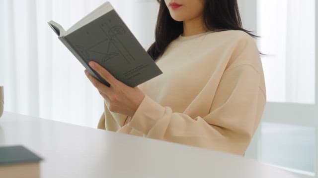 Woman Reading a Book in a Bright Room