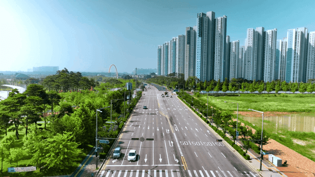 Wide city road with tall buildings.