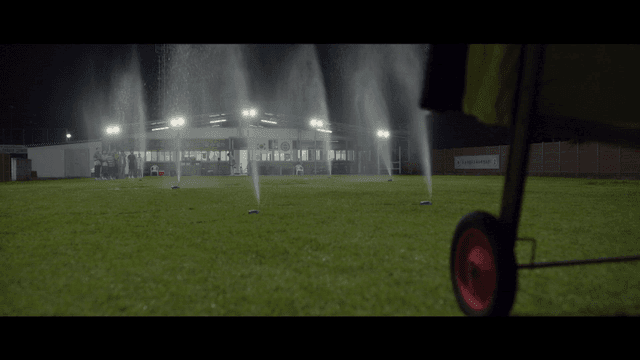 Nighttime sports field with sprinklers on