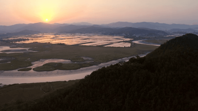 Sunset over expansive wetlands and fields