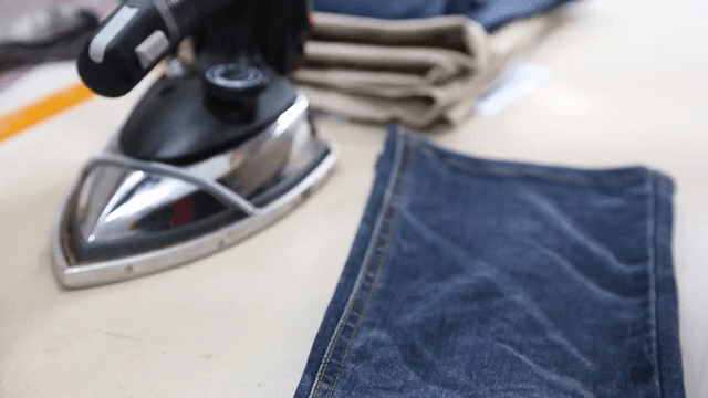 테이블 위에서 데님 청바지 다림질