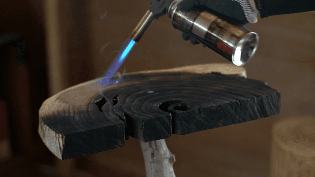 나무에 토치로 불을 붙이는 장면