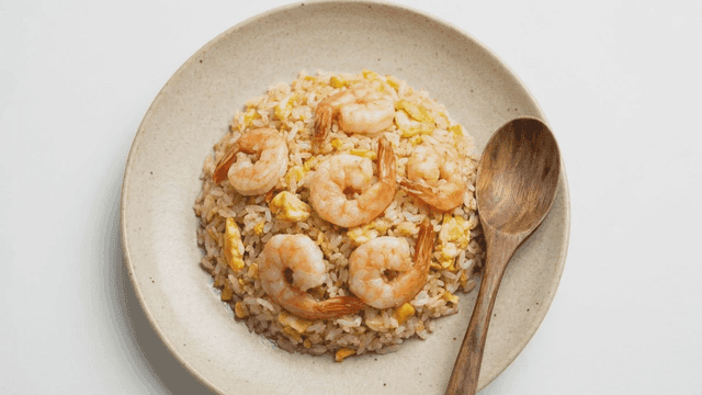 Shrimp fried rice with a wooden spoon