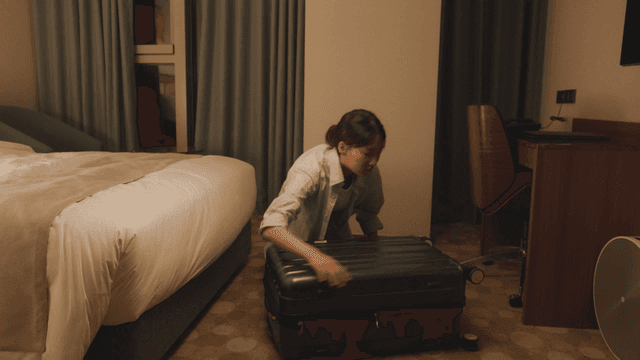 호텔 방에서 짐을 정리하는 여성