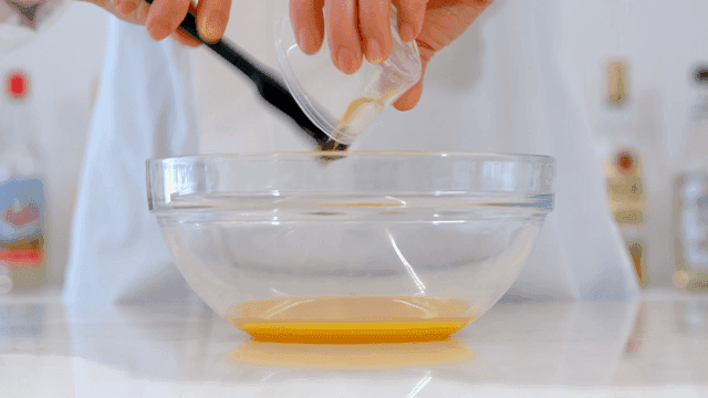 유리 그릇에 주걱으로 재료를 섞는 제빵사