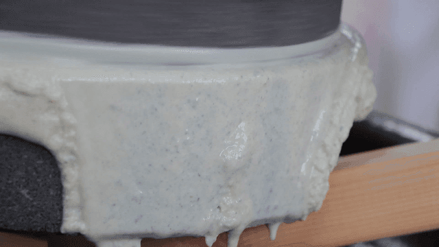 곡물을 갈고 있는 전통 현무암 맷돌