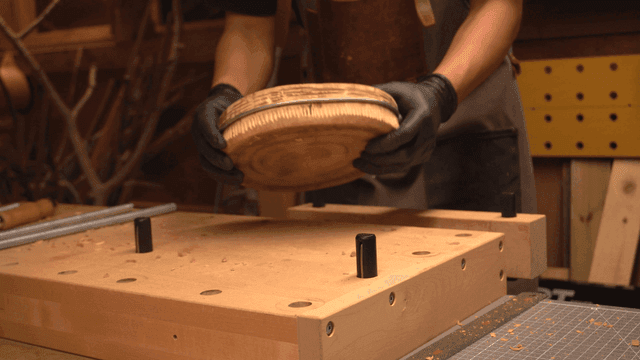 작업장에서 목재에 긴 볼트를 조이는 목공