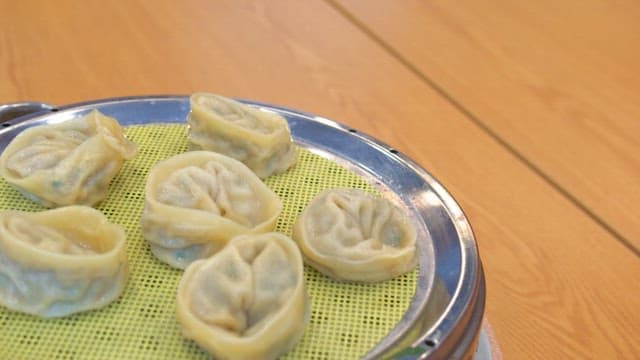 Steamed dumplings plated in a steamer on the table